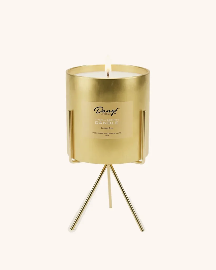 An image of a gold coloured scented candle jar on a candle stand