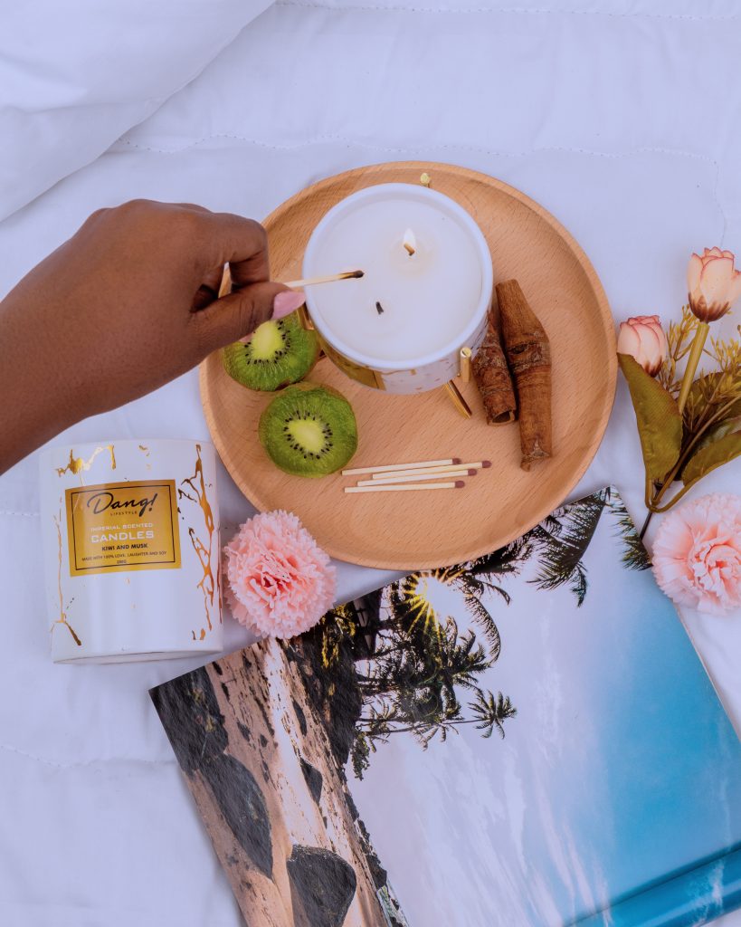 Lady lighting up scented candles one of the effective ways to make a home smell good