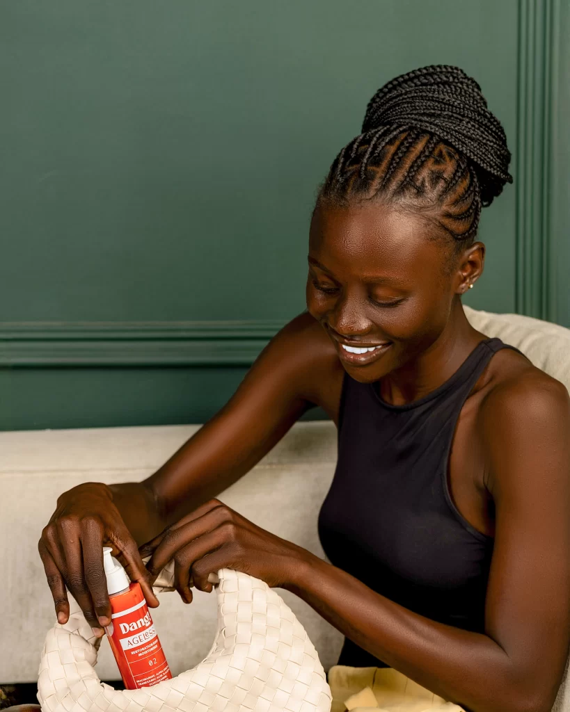 A model putting a moisturising body lotion that's recommended for clearing dark knuckles 