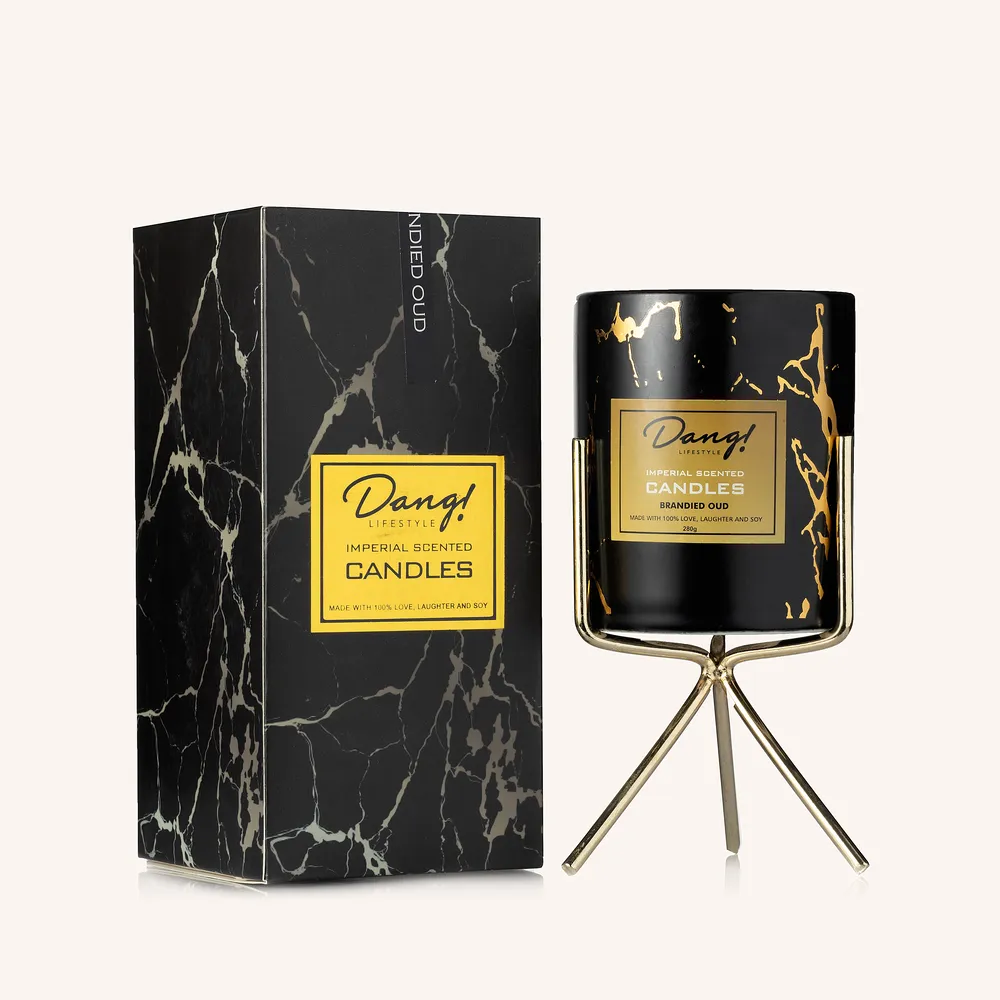 Black and gold coloured candle on a gold coloured stand