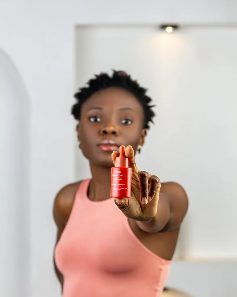 A lady holding a bottle of azelaic acid serum