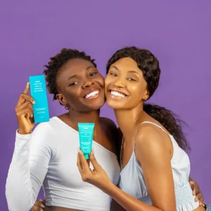 2 models smiling and holding skincare products in their hands, highlighting important products to include in your skincare routine