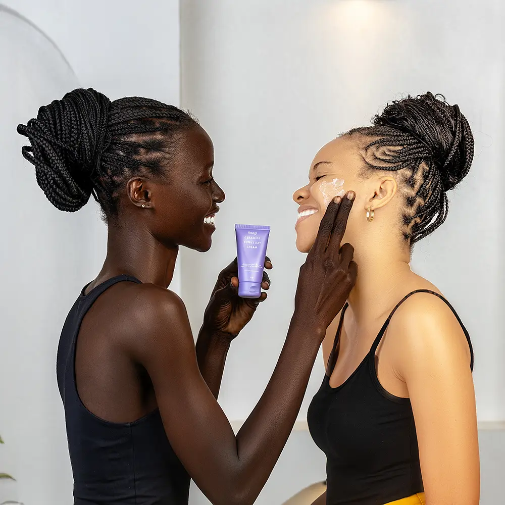Dark skin model applying skincare product which is the Dang face moisturiser rich in ceramides and hydrating ingredients which is very essential for summer season