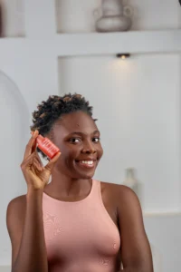 A lay smiling and holding a bottle of azelaic acid serum in her hands an effective skincare product for hyperpigmentation
