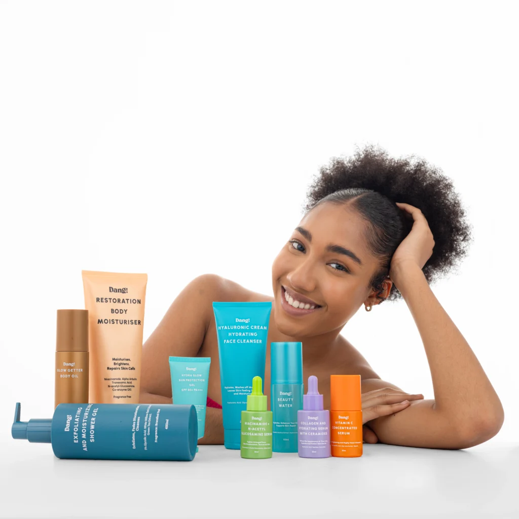 Woman smiling with several Dang! Lifestyle products laid in front of her