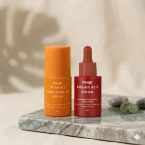 An image of two bottles of serum placed side by side. One being an orange bottled serum with Vitamin C concenterated serum written on the body and the second being azelaic acid serum written on the body