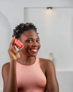 An image of lady holding a bottle of serum in a red bottle named Dang! Azelaic acid serum