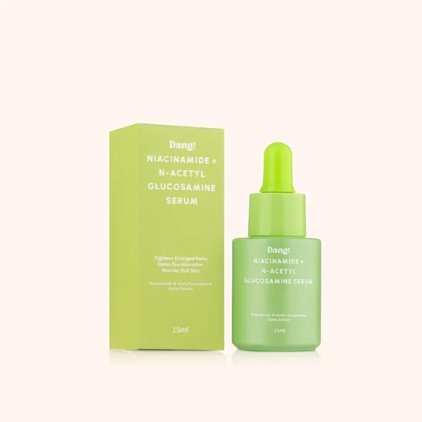A green bottle of serum containing niacinamide placed in front of a white background